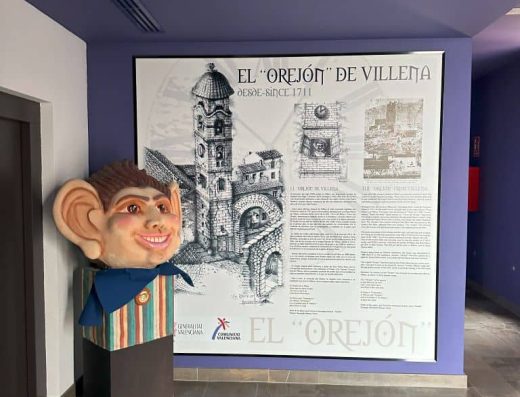 Imagen de panel expositivo y escultura a la izquierda