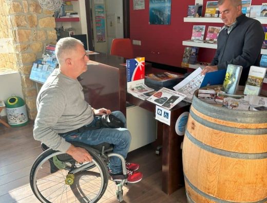 Imagen de usuario en silla de ruedas en mostrador de recepción
