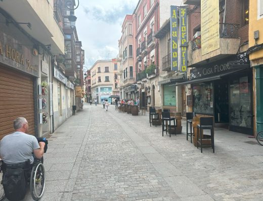 Imagen de un usuario de silla de ruedas recorriendo una calle de plataforma única.