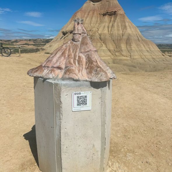 Imagen de una escultura a escala de la formación geológica sobre una peana. En ella hay un código QR.