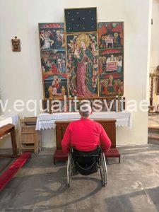 Imagen de una persona usuaria de silla de ruedas observando el retablo gótico.