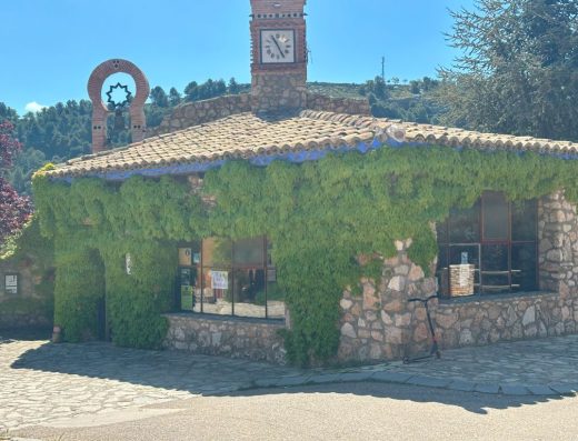 Imagen panorámica de la oficina de turismo con enredaderas en su fachada.