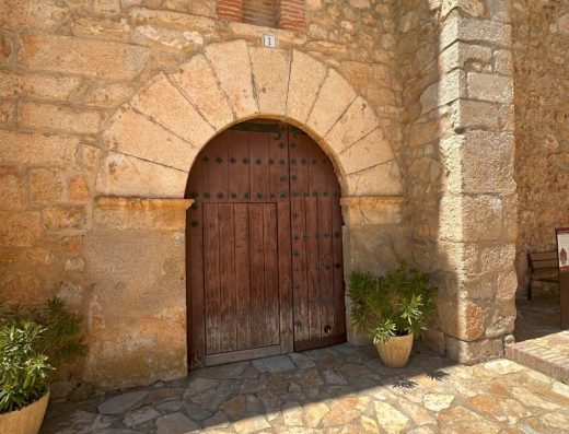 Imagen de la entrada a la iglesia con puerta sobre arco de medio punto.