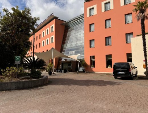 Imagen de puerta de entrada secundaria al hotel. Junto a ella zona de aparcamiento con plazas para PMR.