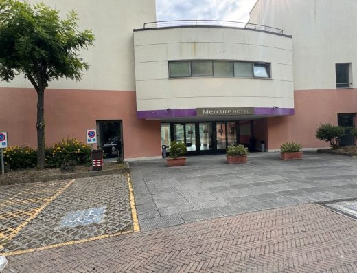 Imagen de la fachada principal del hotel con plaza de aparcamiento PMR junto a la entrada.