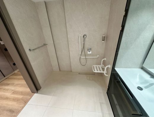 Imagen de la ducha a cota cero con asiento y barras de apoyo.
