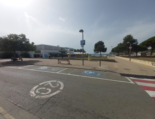 Imagen de varias plazas de aparcamiento reservadas para PMR junto al paseo de la playa. Las plazas están señalizadas horizontal y verticalmente.