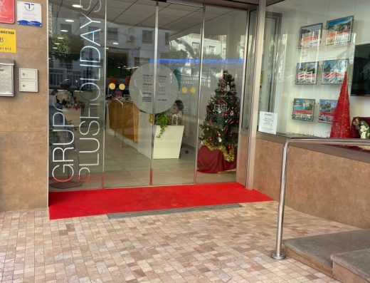 Imagen de la entrada al local con puerta corredera acristalada.