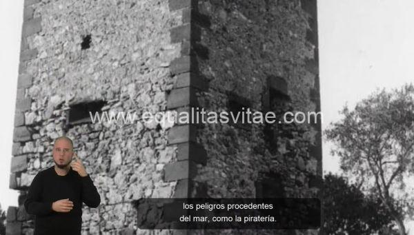 Captura de pantalla de una video signoguía con una interprete de lengua de signos a su izquierda y subtítulos. La imagen muestra un tramo de una torre.