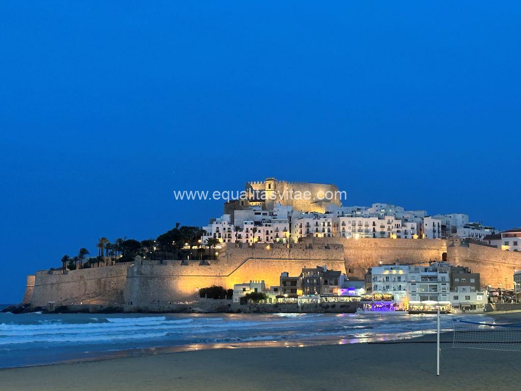 Imagen nocturna panorámica del casco histórico de Peñíscola con el Castillo en lo más alto desde donde se divisa el mar.