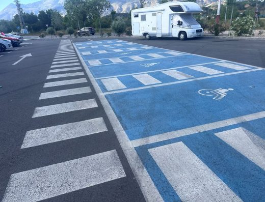 Imagen de 6 plazas de aparcamiento reservadas para PMR en batería. Comparten espacio de transferencia señalizado con marcas viales.