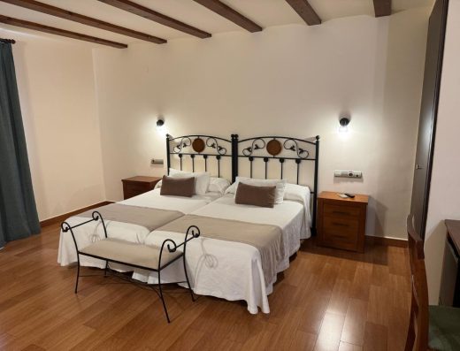 Imagen de una habitación con dos camas individuales juntas.