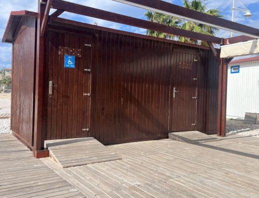 Imagen del pabellón de madera con dos puertas, una al aseo adaptado y otra al vestuario, ambas con rampa.