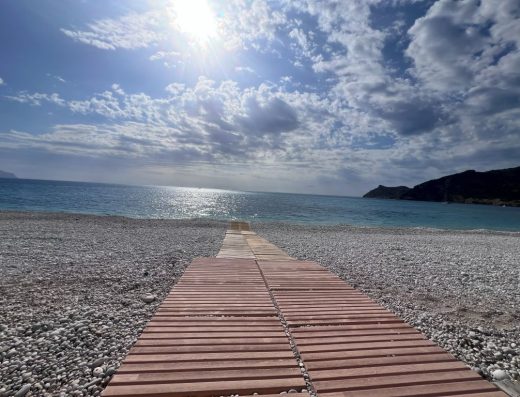 Imagen de sendero de tarima que lleva hasta la orilla del mar.