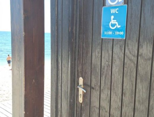 Imagen de la puerta de entrada al baño adaptado, señalizada con pictograma de accesibilidad.