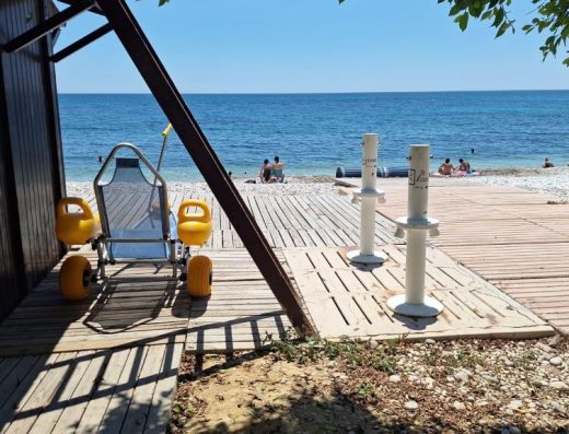 Imagen de una silla anfibia junto al puesto de playa accesible.