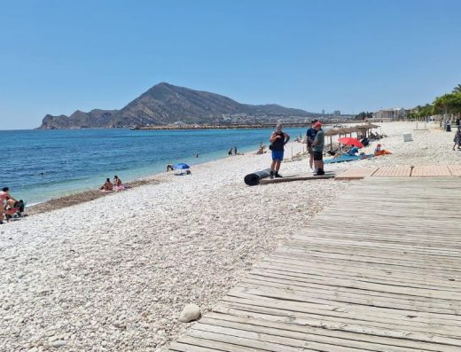 Imagen de tarima de madera sobre los cantos rodados de la playa.