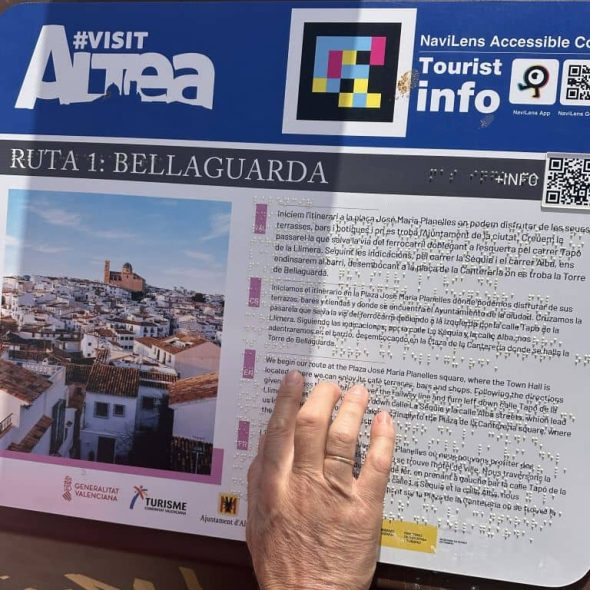 Imagen de una mano tocando un panel informativo de Altea en braille.
