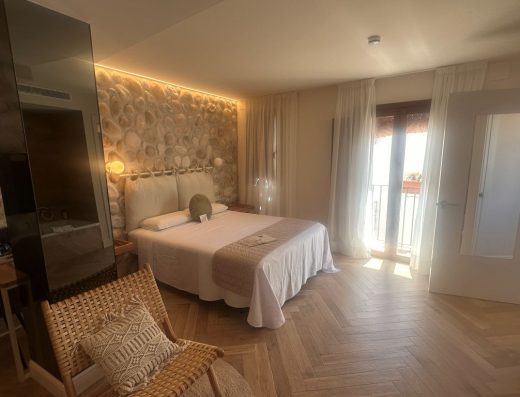 Imagen del interior de la habitación con cama de matrimonio y gran espacio a los pies.