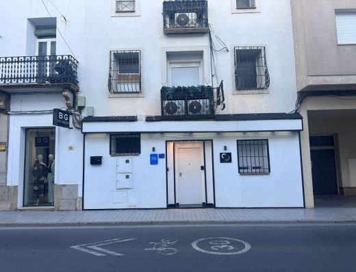 Imagen de la fachada del hostal con varias plantas. En los balcones se han colocados las máquinas de aire acondicionado.