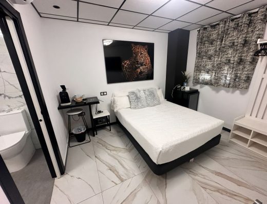 Imagen del interior de la habitación adaptada con una cama de matrimonio. A la izquierda la entrada al baño.