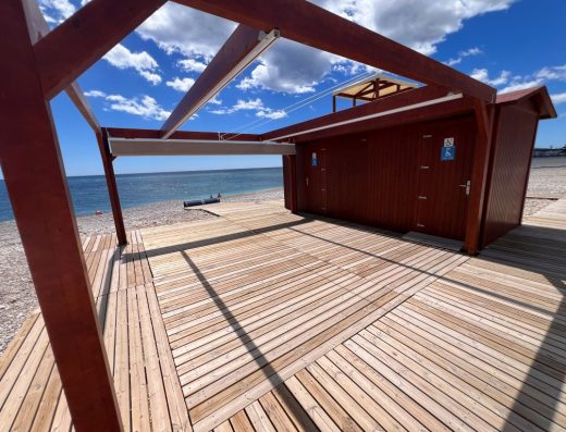 Imagen del punto de playa accesible, una zona con casetas de madera, tarima y pérgola.