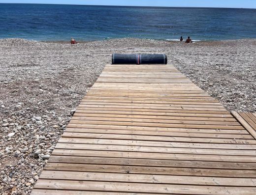 Imagen de la tarima de madera con rollo de lona al final para acercar hasta la orilla.