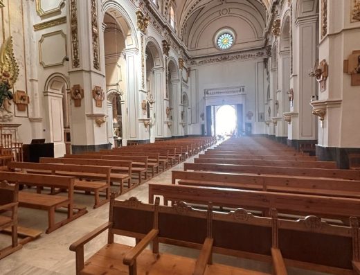 Imagen de la nave central vista desde la cabecera. Al fondo la puerta de entrada abierta y sobe ella un rosetón.
