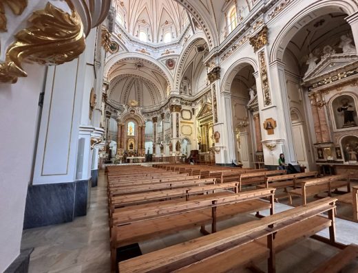 Imagen panorámica de la nave central de la iglesia con el retablo mayor al fondo.