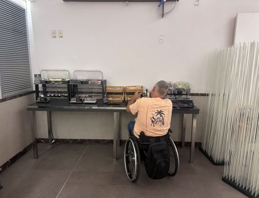 Imagen de una persona en silla de ruedas junto al espacio del buffet donde se encuentra el tostador y la cafetera.