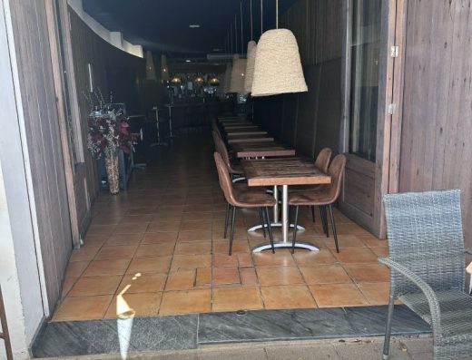 Imagen de la entrada al restaurante con una pequeña rampa a la izquierda. Las puertas están abiertas de par en par.