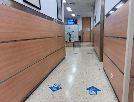 Imagen de un pasillo del centro de salud con flechas direccionales representadas en el suelo.