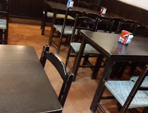 Imagen de la zona de mesas con mesas de madera con travesaño.