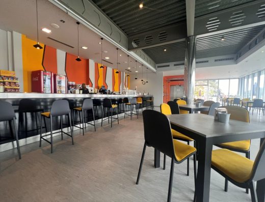 Imagen del interior del restaurante. A la izquierda la barra y a la derecha mesas junto a la cristalera.