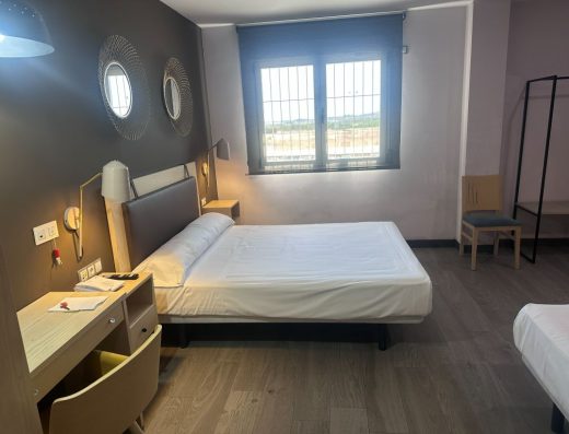 Imagen del interior de la habitación de un hotel con una cama de matrimonio.
