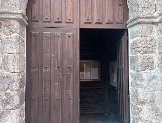 Imagen de la puerta de entrada al templo. Puerta de madera bajo un arco de medio punto.