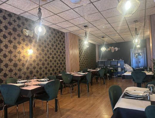 Imagen del interior del comedor con mesas cuadradas preparadas para los comensales.