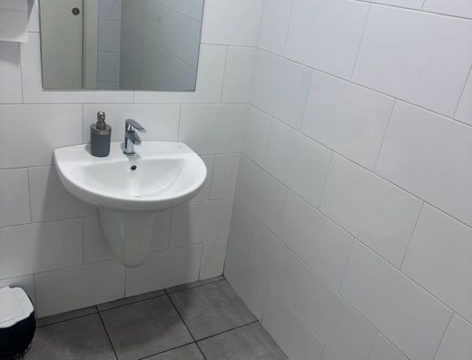 Imagen del lavabo, sin pie y con grifo monomando. Sobre el hay un espejo.
