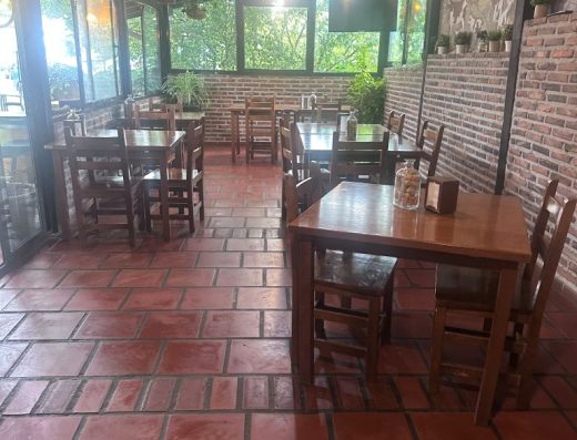 Imagen del interior del comedor de estilo rural con mesas de madera.