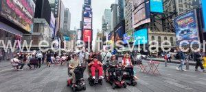 Imagen de un grupo de personas, algunas en silla de ruedas, posando para foto en la gran manzana.